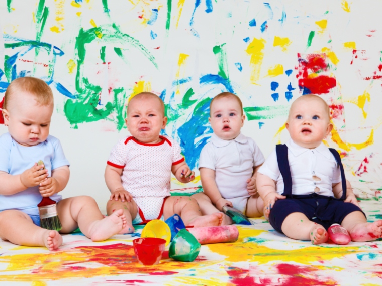 Babies with paints and paintbrushes